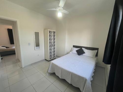 a bedroom with a bed and a ceiling fan at Casa 1 km da Praia Enseada com Garagem in Guarujá