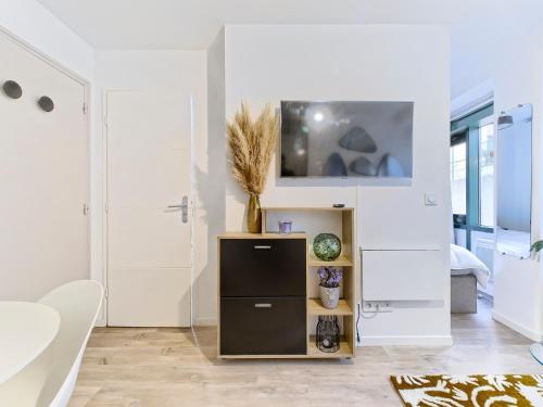 - un salon blanc avec une télévision murale dans l'établissement Riviera Vibes - AC - Wifi & Breakfast - 8 min walk to beach, à Nice