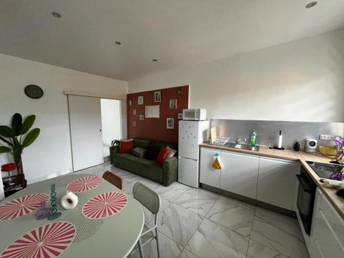 a kitchen and living room with a table and a couch at House Groovy in Le Marin