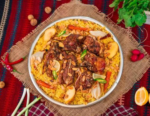 Un plato de comida con carne y verduras sobre una mesa. en المزار لوج, en Al Mazār
