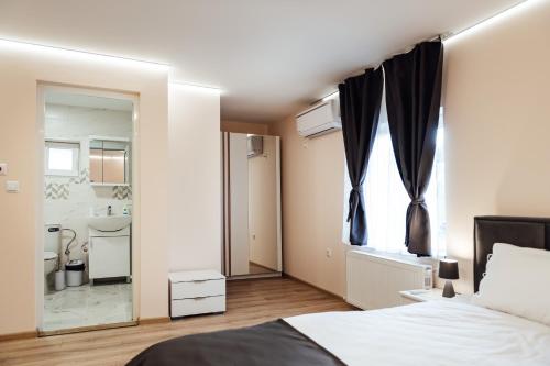Un dormitorio con una cama grande y un baño. en Апартамент Инфинити, en Sapareva Banya