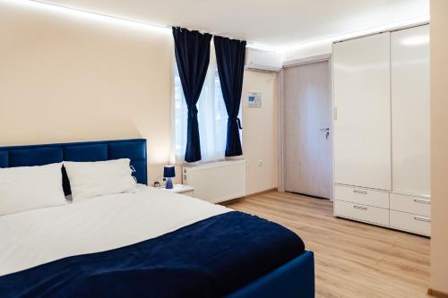 Un dormitorio con una cama azul y blanca y una ventana. en Апартамент Инфинити, en Sapareva Banya