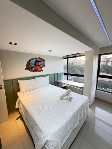 a bedroom with a large white bed with a window at Suites Premium 2 quartos in João Pessoa