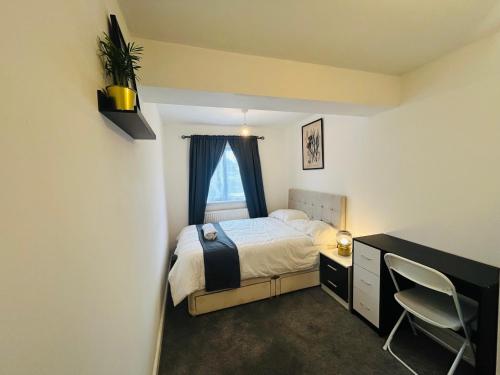 a bedroom with a bed and a desk and a window at Snug room II in Wellingborough in Wellingborough