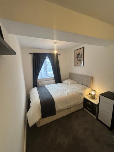 a bedroom with a large bed and a window at Snug room II in Wellingborough in Wellingborough