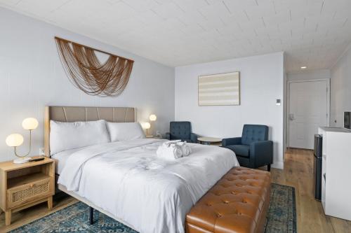 a bedroom with a bed and two blue chairs at Showboat Hotel in Himrod