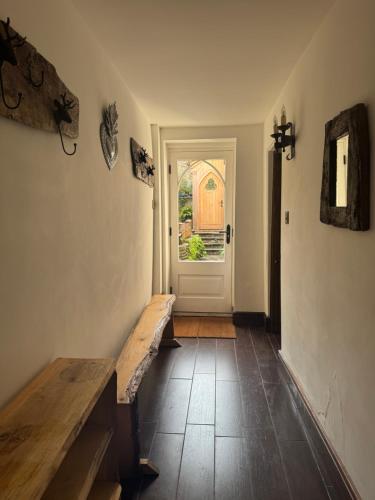 a hallway with a door and a bench and a window at The Oak House in Glastonbury