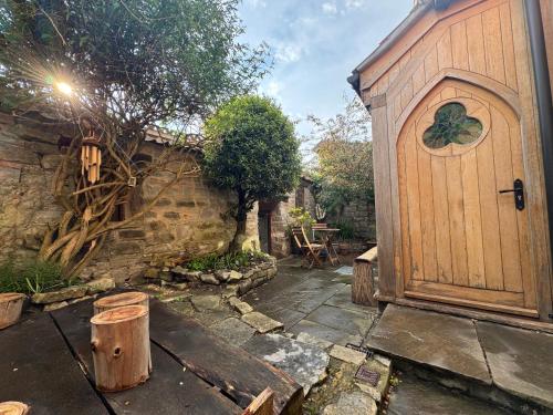 a large wooden door in a garden with a table at The Oak House in Glastonbury