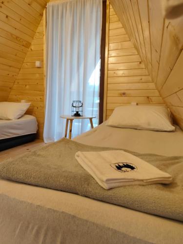 a bedroom with two beds and a window at Vikendica Monte Pino Romanija in Sokolac