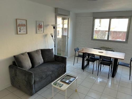 un salon avec un canapé et une table dans l'établissement Appartement centre ville avec place de parking privée et balcon, à Montauban