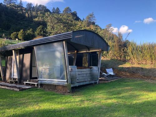 a small house sitting on the grass in a field at Gorgeous Glamping in Karangahake in Karangahake