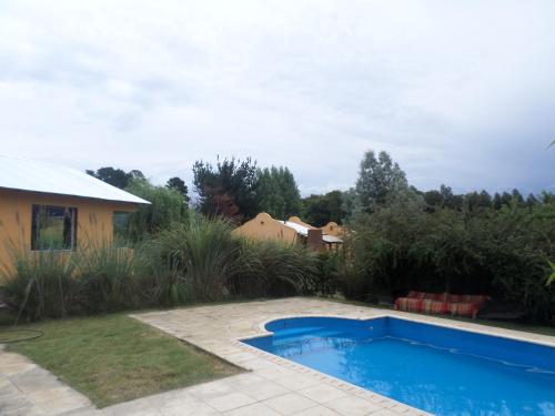 a swimming pool in the yard of a house at Complejo Dulcería El Cazador y cabañas in Tandil