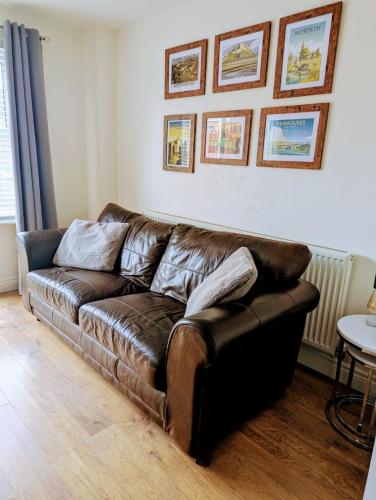 a brown leather couch sitting in a living room at Sleeps up to 8 guests - Modern townhouse near Newcastle in Willington Quay