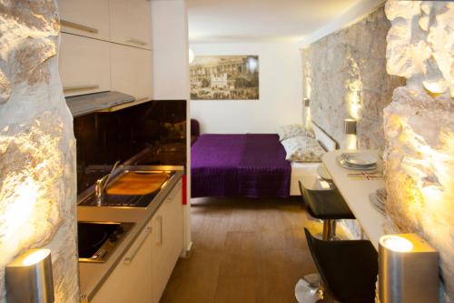 a room with a kitchen and a bedroom with a bed at Villa Veli Varos in Split