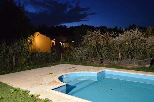 a swimming pool in a yard at night at Complejo Dulcería El Cazador y cabañas in Tandil