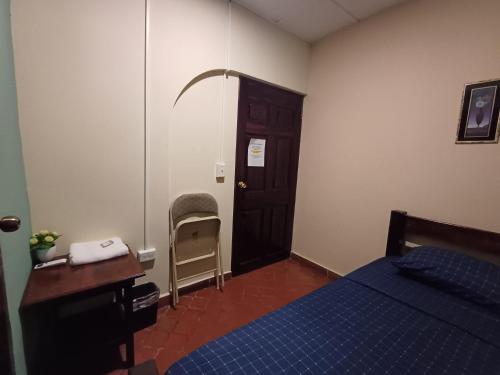 a bedroom with a bed and a desk and a door at BlueRock Hostal in David