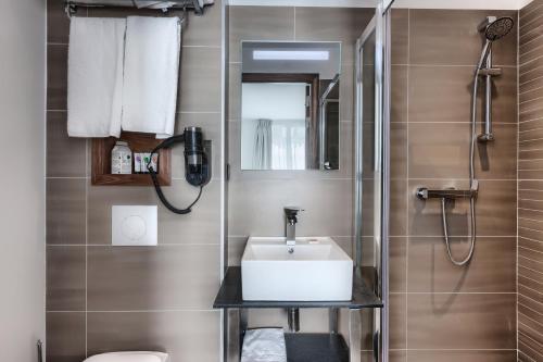 un baño con lavabo y ducha en Le Trente, en París