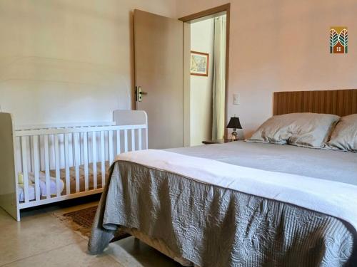 a bedroom with a bed and a baby crib at Chales Vinhas da Harmonia l Pousada em Cunha SP in Cunha