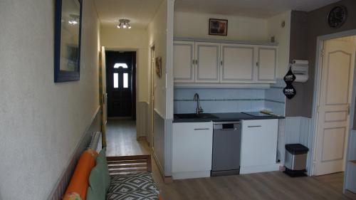 une cuisine avec des armoires blanches et un évier dans l'établissement Appartement hippocampe bord de mer, au Barcarès