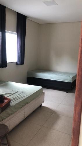 a bedroom with two beds and a window at Beach House! in Ilhéus