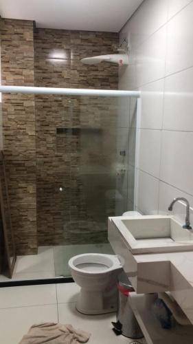 a bathroom with a shower and a toilet and a sink at Beach House! in Ilhéus