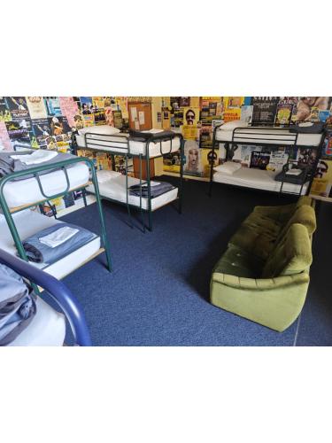 a room with bunk beds and a couch on the floor at Tuatara Lodge in Invercargill