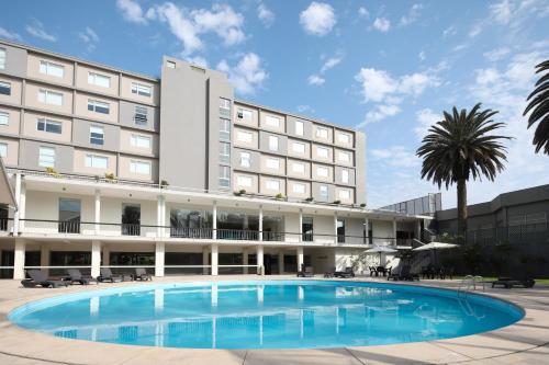 a hotel with a large pool in front of a building at Casa Andina Select Chiclayo in Chiclayo