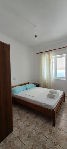 a large bed in a room with a window at Sunset Boulevard Rooms in Qeparo