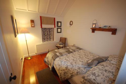 Dormitorio pequeño con cama y lámpara en Tigín Tuí en Carndonagh