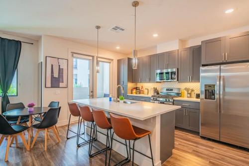 a kitchen with a large island and a table with chairs at Modern 1BR Kierland Commons, TPC Golf, Pool, Gym, W-D in Scottsdale