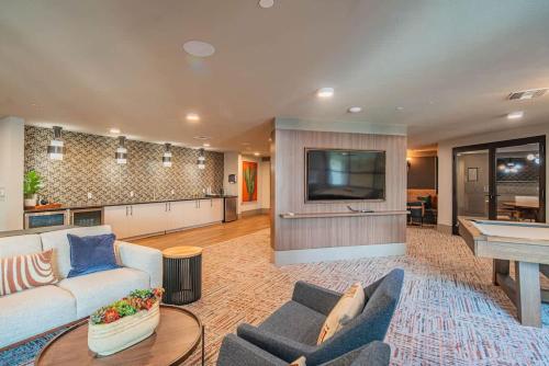 a living room with a couch and a tv and a table at Modern 1BR Kierland Commons, TPC Golf, Pool, Gym, W-D in Scottsdale