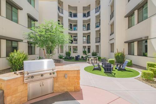 a barbecue grill in a courtyard with a building at Modern 1BR Kierland Commons, TPC Golf, Pool, Gym, W-D in Scottsdale