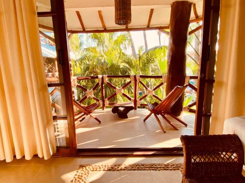 a room with a large glass door to a balcony at Hotel Para Ti - Adults Only in Holbox Island
