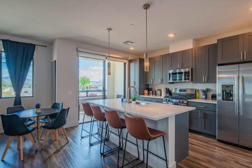 a kitchen with a large island and a table with chairs at Peaceful 1BR Kierland Common, TPC Golf, Pool, Gym, W-D in Scottsdale
