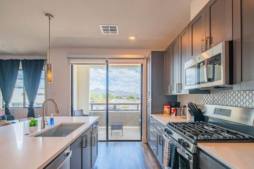 a kitchen with a sink and a stove at Peaceful 1BR Kierland Common, TPC Golf, Pool, Gym, W-D in Scottsdale