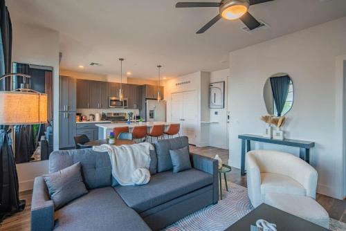 a living room with a blue couch and a kitchen at Peaceful 1BR Kierland Common, TPC Golf, Pool, Gym, W-D in Scottsdale