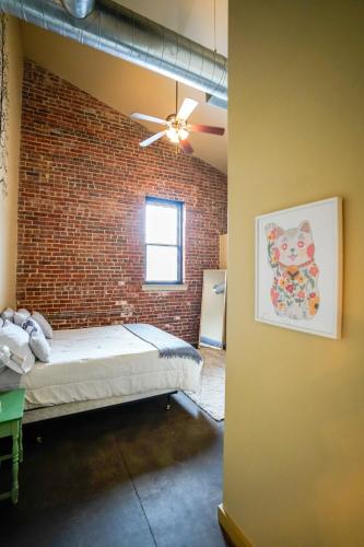 a room with a brick wall and a bed at Industrial Escape in Lawrence