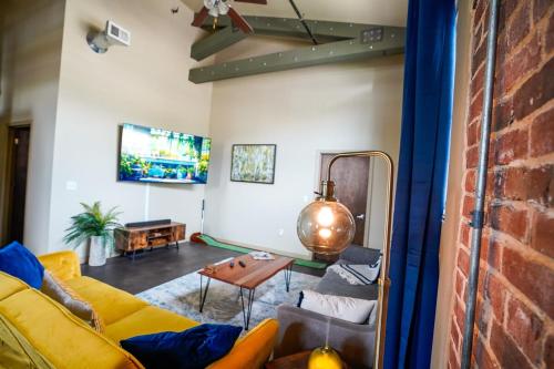 a living room with a yellow couch and a brick wall at Industrial Escape in Lawrence