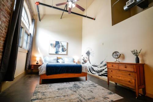 a bedroom with a bed and a dresser and a window at Industrial Escape in Lawrence