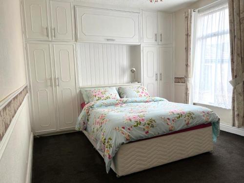 a white bedroom with a bed and a large window at Stylish and Spacious two-bedroom Apartment in Blackpool