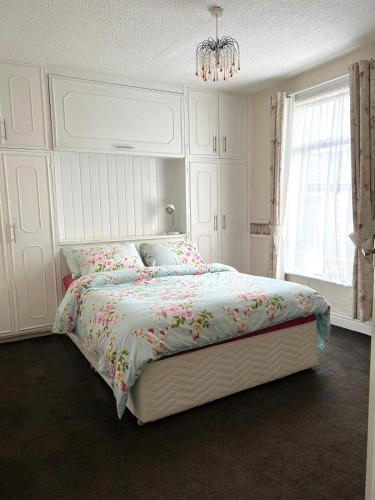 a bedroom with a large white bed with flowers on it at Stylish and Spacious two-bedroom Apartment in Blackpool