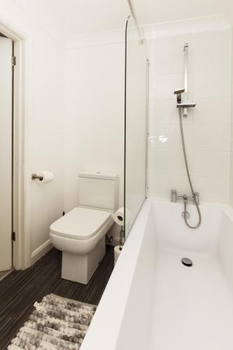 a white bathroom with a toilet and a shower at Stunning 2-BR Home Gravesend Town Centre, Kent in Gravesend