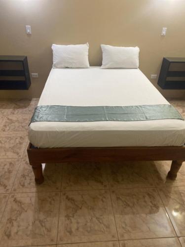 a bed with two pillows on top of it at Marshan villa in Montego Bay
