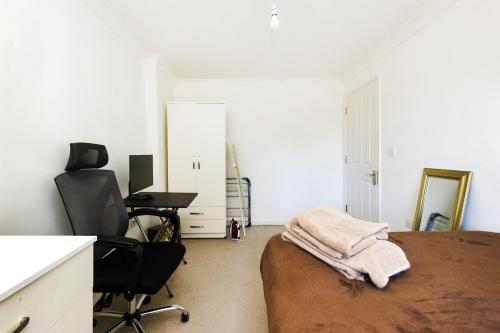a bedroom with a bed and a desk and a chair at Stunning 2-BR Home Gravesend Town Centre, Kent in Gravesend