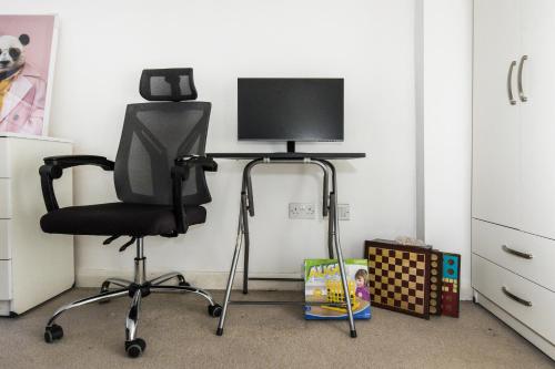a computer chair with a monitor on top of it at Stunning 2-BR Home Gravesend Town Centre, Kent in Gravesend