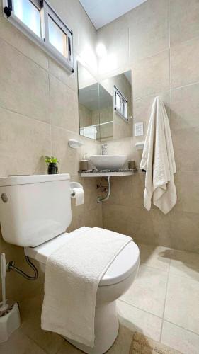 a bathroom with a white toilet and a sink at Dalia Pampa in RSA