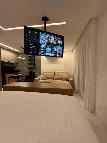 a bedroom with a bed and a flat screen tv at Loft Beira-Mar Luxuoso PRAIA DO CANTO APART HOTEL in Vitória