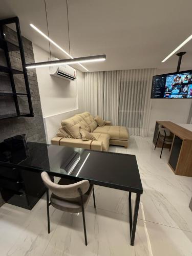 a living room with a table and a couch at Loft Beira-Mar Luxuoso PRAIA DO CANTO APART HOTEL in Vitória