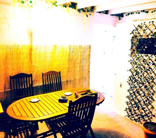 a wooden table and chairs in a room at MMrooms 1 διπλό κρεβάτι in Tinos Town
