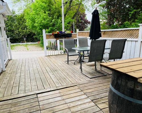 a wooden deck with a table and chairs and an umbrella at Barker House 3# Suite-heart of oldtown in Niagara on the Lake